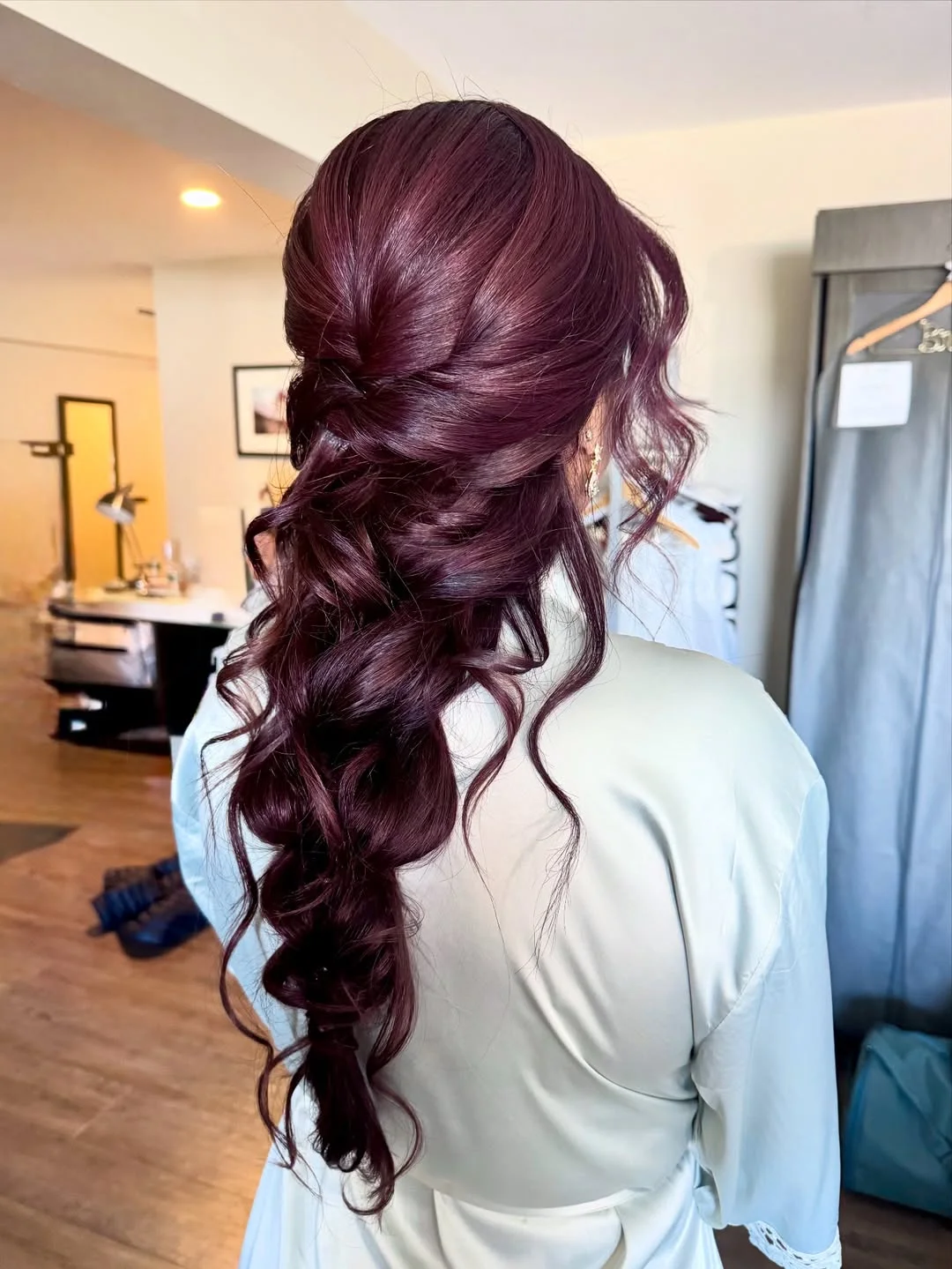 boho summer wavy hairstyle 2026 Soft Burgundy Waves with a Twisted Low Boho Finish