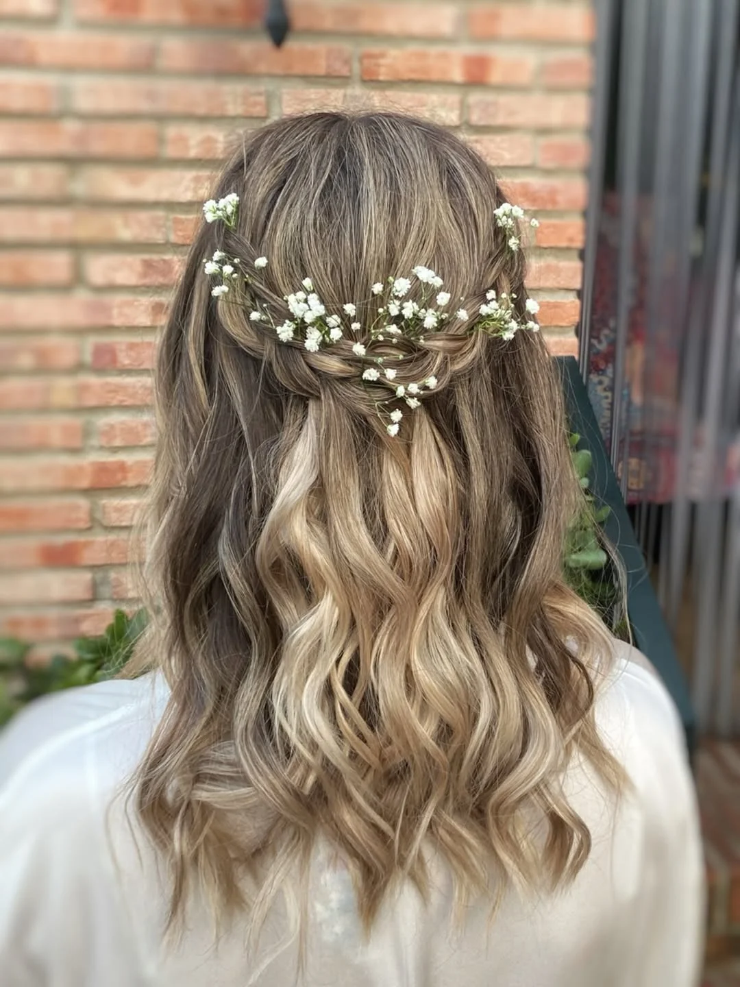 boho summer wavy hairstyle 2026 Loose Braided Crown with Soft Waves and Floral Details