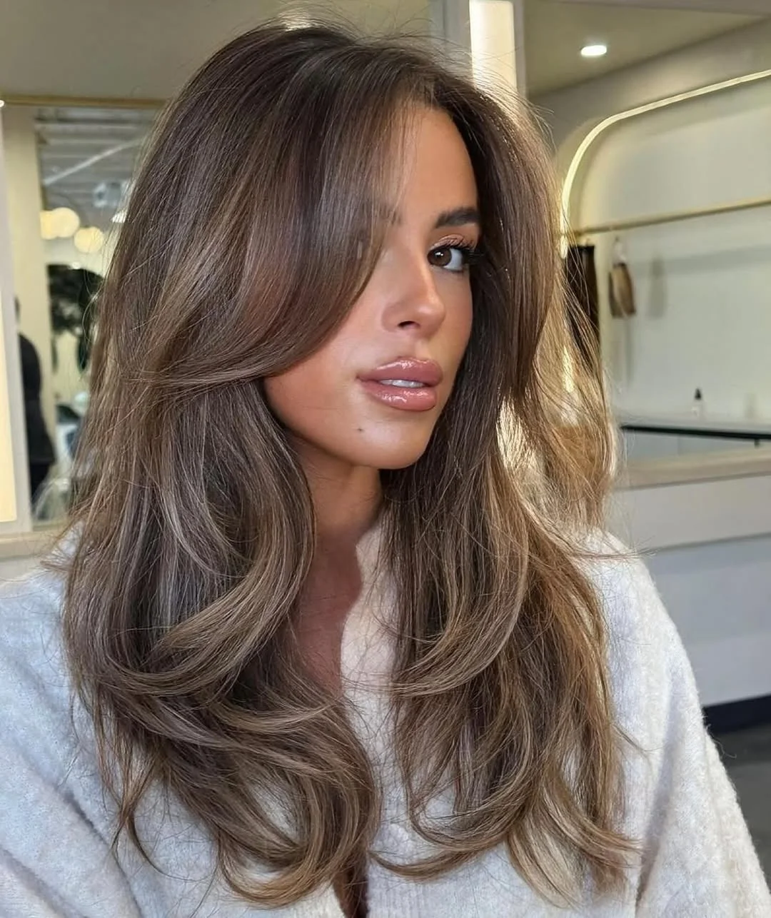 glossy summer hair color for brown skin 2026 Cool Beige Brunette With Feathered Summer Layers