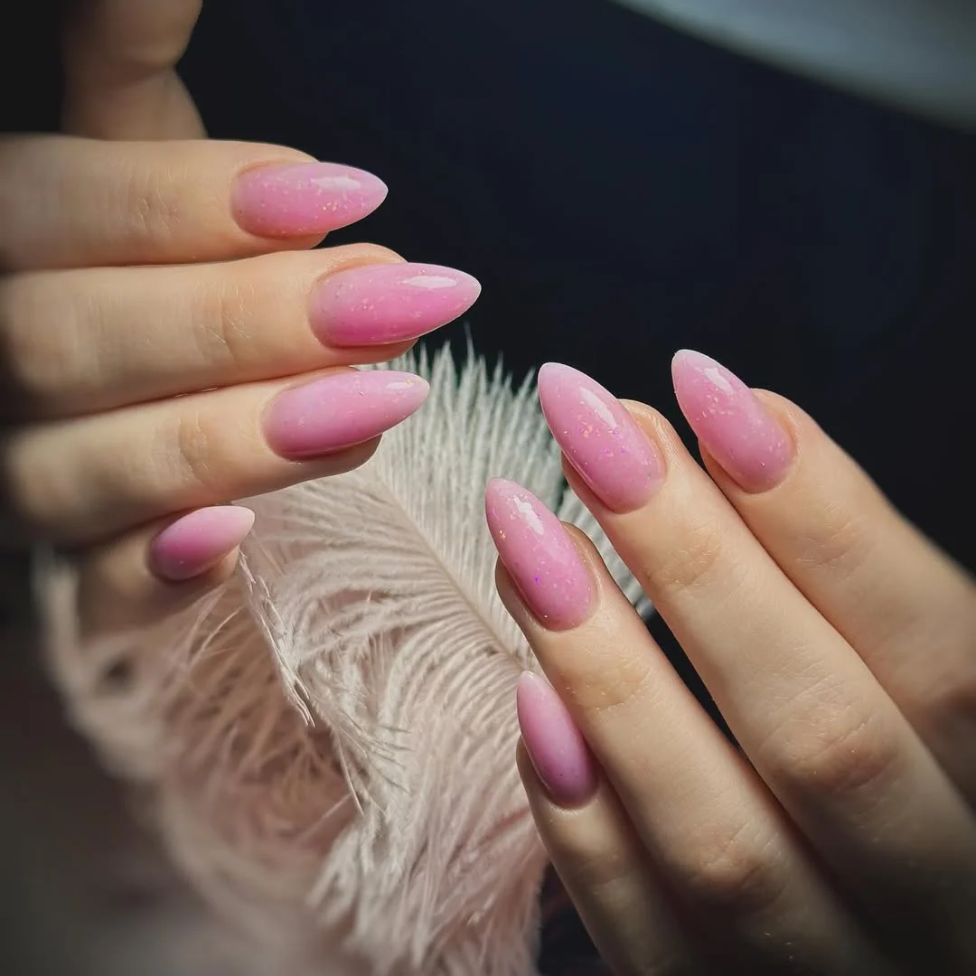pink summer nails 2026 Glossy Pink Almond Nails With Fairy Dust Sparkle