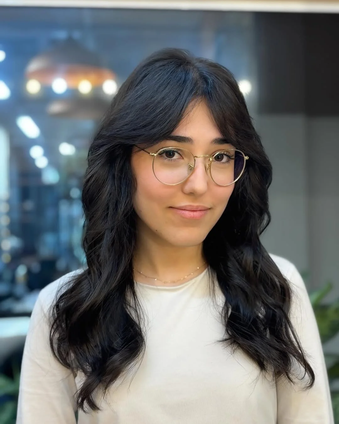 salon summer haircuts with bangs 2026 Soft Black Waves With Delicate Face Framing Bangs