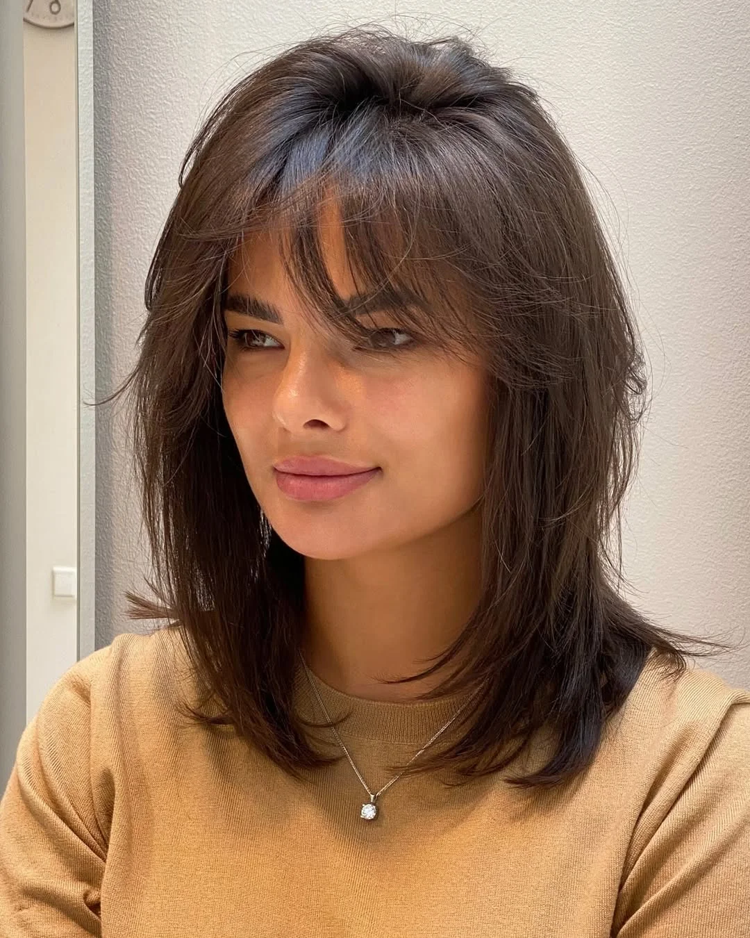 salon summer haircuts with bangs 2026 Soft Espresso Midi Cut With Wispy Movement