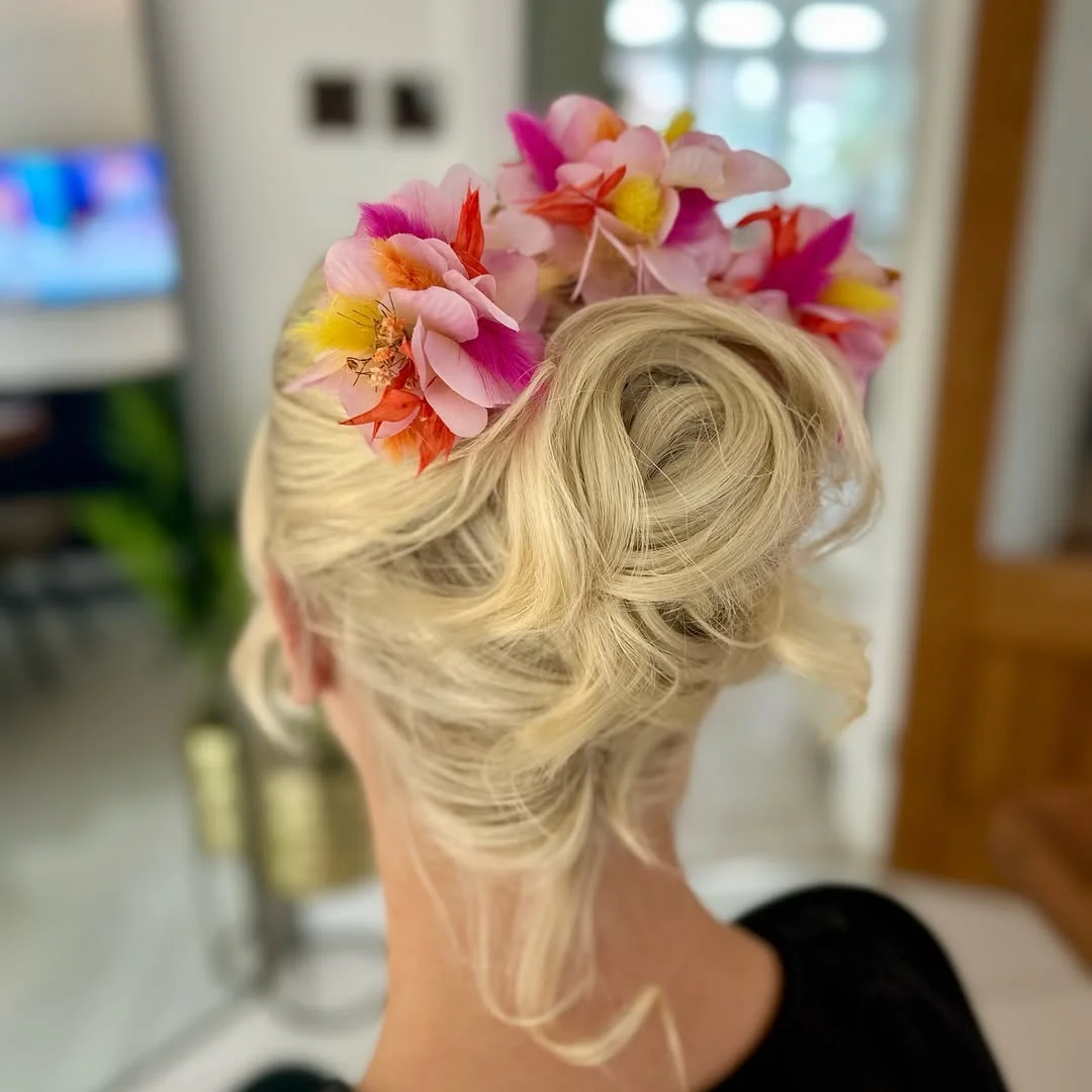 stylish summer wedding guest hairstyles 2026 Floral Statement Updo for Tropical Outdoor Weddings
