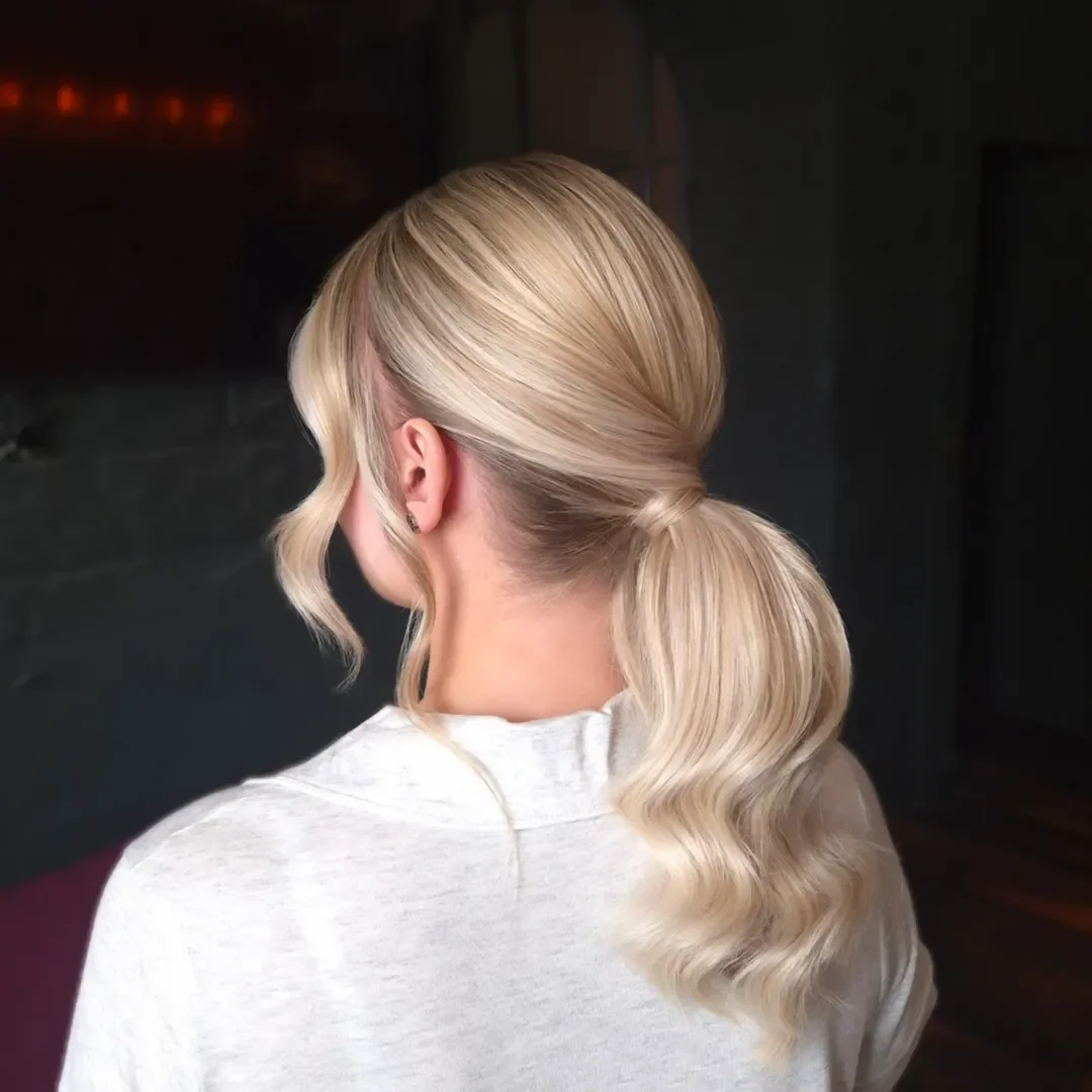 stylish summer wedding guest hairstyles 2026 Low Blonde Ponytail with Soft Luxury Waves