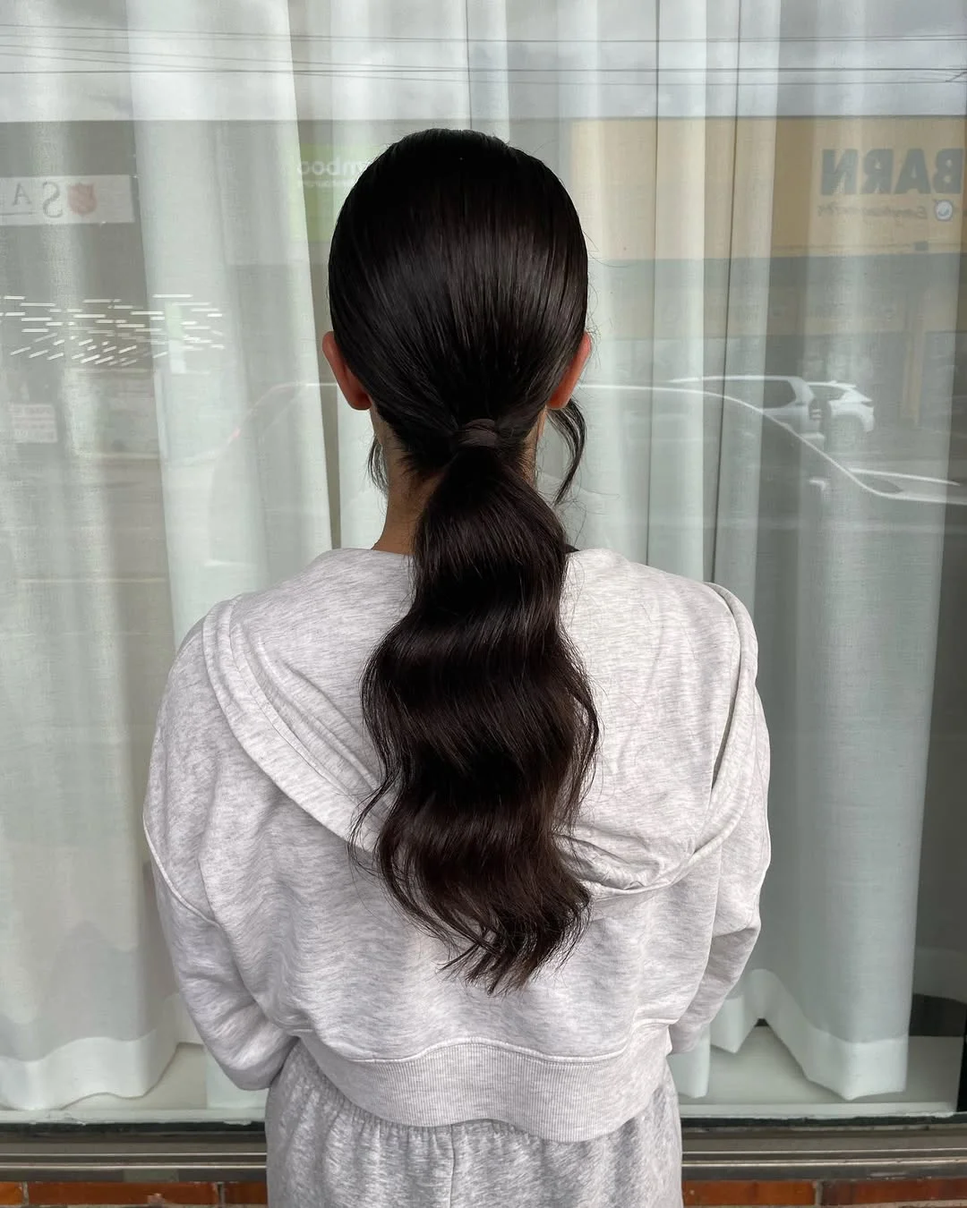 stylish summer wedding guest hairstyles 2026 Sleek Low Ponytail with Soft Summer Waves