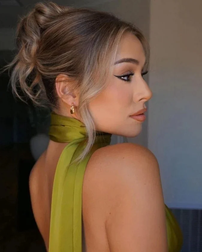stylish summer wedding guest hairstyles 2026 Messy Blonde Bun with Face-Framing Layers