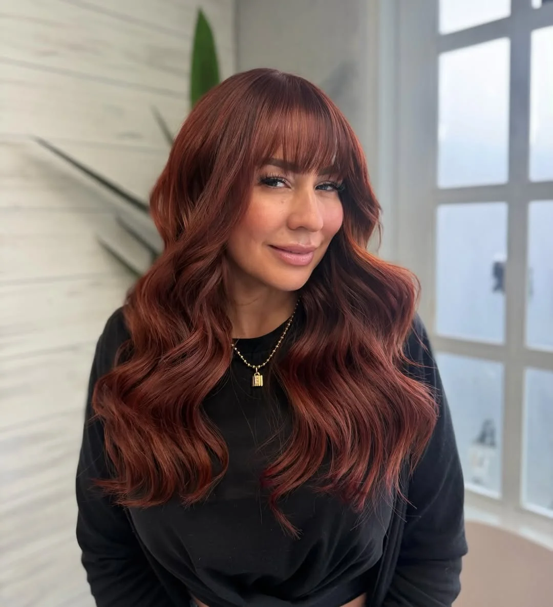 sun-kissed summer auburn hair color 2026 Deep Wine Auburn with Full Fringe Energy